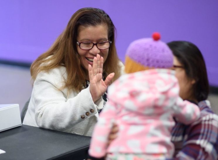 woman giving a high-five to a baby