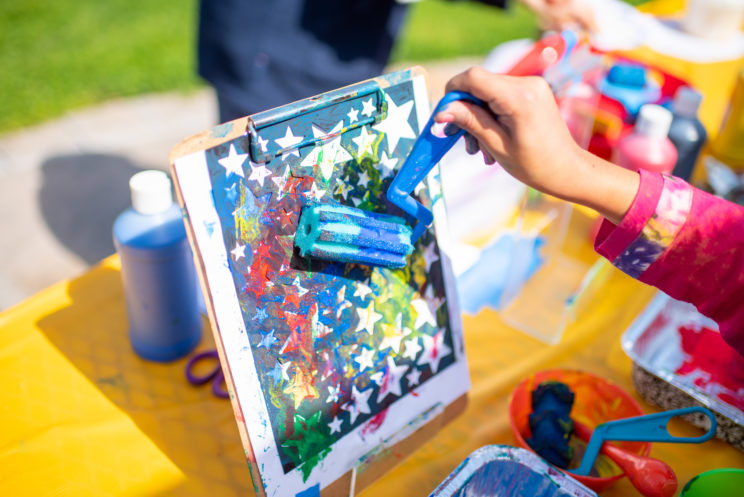 Image of child's hand painting stars