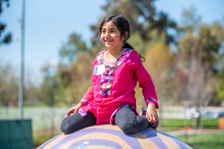 (girl on playground who is smiling)